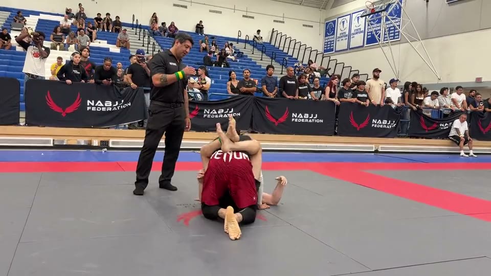 Wide phone footage of a no-gi match from the mat edge